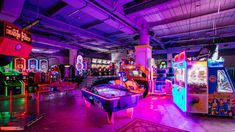 a room filled with arcade machines and neon lights