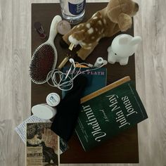 a table topped with books and toys on top of a wooden floor next to a bottle of water