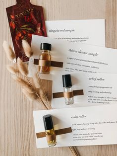 three bottles of perfume sitting on top of each other next to some paper with writing