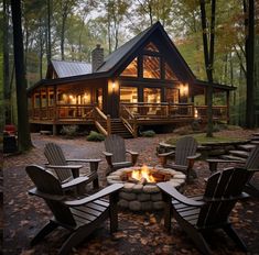 a fire pit in front of a cabin with adiron chairs around it and steps leading up to the deck