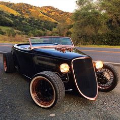 an antique car is parked on the side of the road