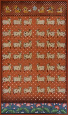 an orange and blue wall hanging with cows in the center, on top of polka dot fabric