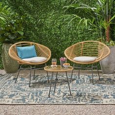 two wicker chairs sitting next to each other on top of a blue and white rug