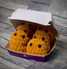 two stuffed bears in a box on the floor, one is yellow and the other is brown