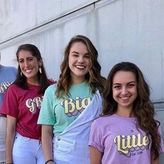 a group of young women standing next to each other in front of a wall smiling at the camera