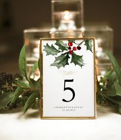 the table numbers are decorated with holly leaves and red berries, along with pine cones