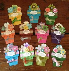 many small boxes with flowers on them sitting on a wooden table next to each other