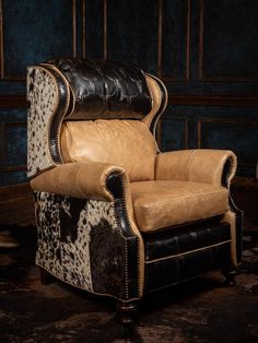 a brown and black chair sitting in front of a blue wall with animal print on it