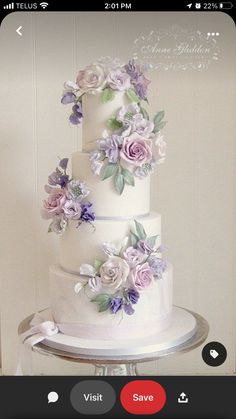 a white wedding cake with purple flowers on top