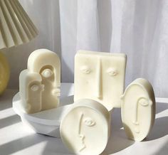 three pieces of soap sitting next to each other on a white tableclothed surface