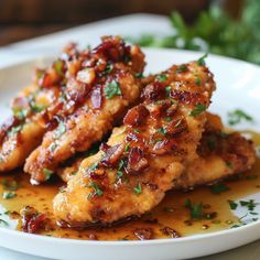 two pieces of chicken on a plate with sauce and parsley sprinkled around it