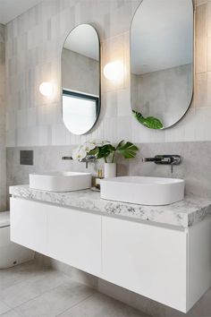 a bathroom with two sinks and mirrors on the wall