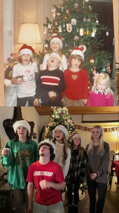 a group of people standing next to each other in front of a christmas tree with pictures on the wall