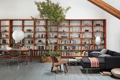 a living room filled with furniture and bookshelves next to a wooden flooring