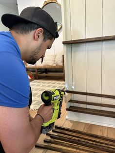 a man in blue shirt holding a cordless drill