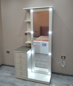 a white mirrored closet with drawers and a bed in the corner is lit up by led lights