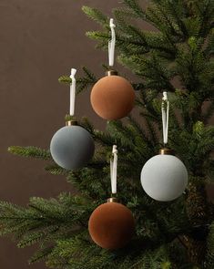 three ornaments are hanging from a christmas tree