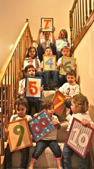 a group of children holding up numbers on the stairs