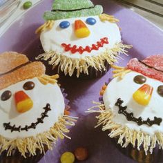 three frosted cupcakes decorated like snowmen