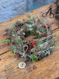 a wreath is sitting on top of a wooden table next to scissors and other items