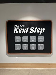 a black and white sign that says take your next step on the side of a wall