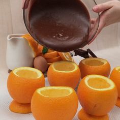 someone is pouring chocolate into some oranges