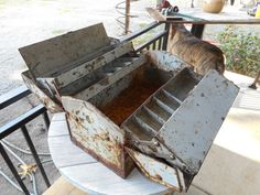 an old metal box sitting on top of a wooden table