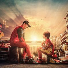 two men sitting next to each other on top of a race car in front of a sunset