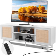 a flat screen tv sitting on top of a white entertainment center next to a remote control