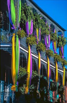 colorful streamers hanging from the side of a building with balconies on it