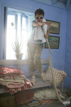 a woman is cleaning the floor with a vacuum cleaner in her bedroom - stock image