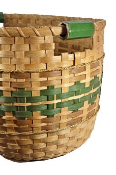 a close up of a woven basket on a white background with a green plastic handle