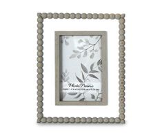 a wooden frame with beading around the edges and an image of leaves on it