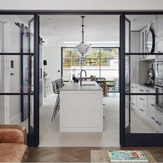 an open kitchen and living room with sliding glass doors that lead to the dining area