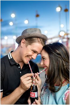 a man and woman smile as they hold their straws in front of each other