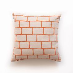 an orange and white pillow on a white background