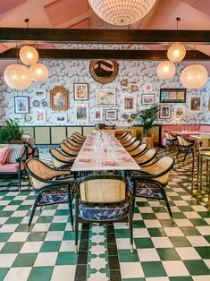 a dining room with checkered flooring and chandeliers hanging from the ceiling