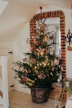 a small christmas tree in a basket on the floor