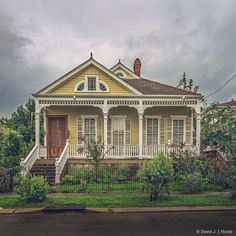 a yellow house sitting on the side of a road