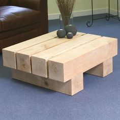 a wooden coffee table with two vases on top