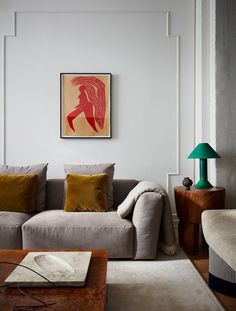 a living room with a couch, coffee table and pictures on the wall above it