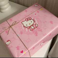 a pink hello kitty gift box sitting on top of a white dresser