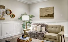 a living room filled with furniture and a painting on the wall