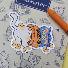 a close up of a sticker on a table with an orange pen and paper