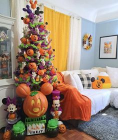 a decorated halloween tree in the corner of a living room with mickey mouse and friends decorations