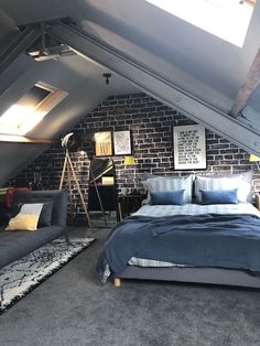 an attic bedroom with exposed brick walls and gray carpeted flooring is shown in this image