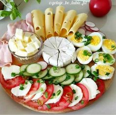 a platter filled with different types of vegetables and cheese on top of each other