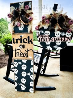 two halloween decorations are sitting on the porch with black and white signs that say trick or treat