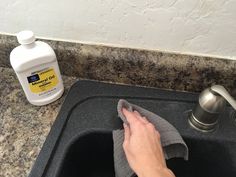 a person cleaning a kitchen sink with a microfiber and dish cloth in front of it