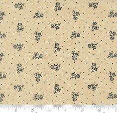 a beige background with black flowers and dots on the bottom half of it, as well as a ruler